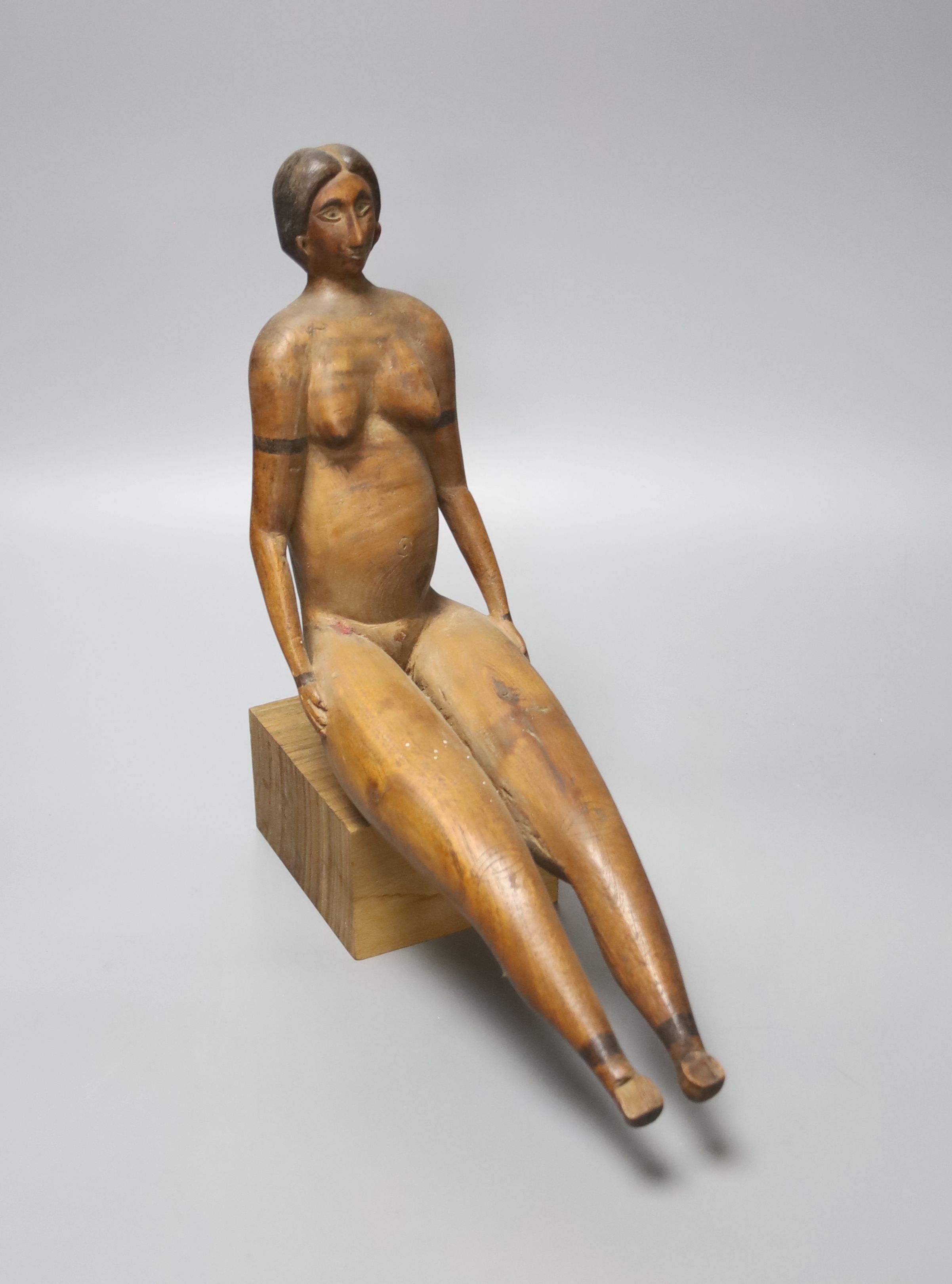 A South American carved wood figure of a seated nude lady, 20th century